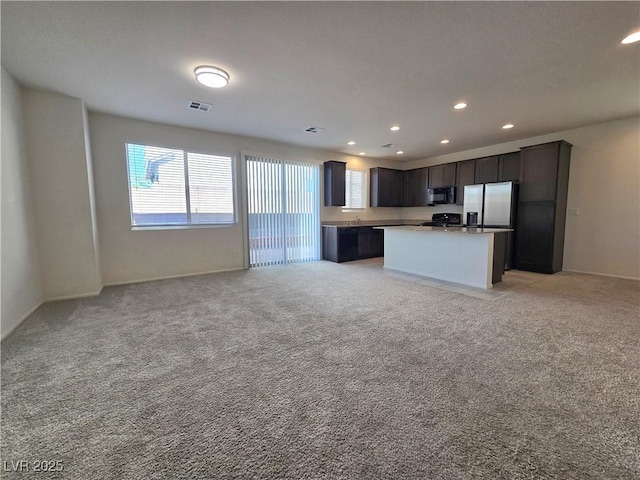 5817 Bonita Rose St, Las Vegas, NV 89113 - kitchen featuring black microwave, stainless steel fridge with ice dispenser, recessed lighting, open floor plan, and light carpet