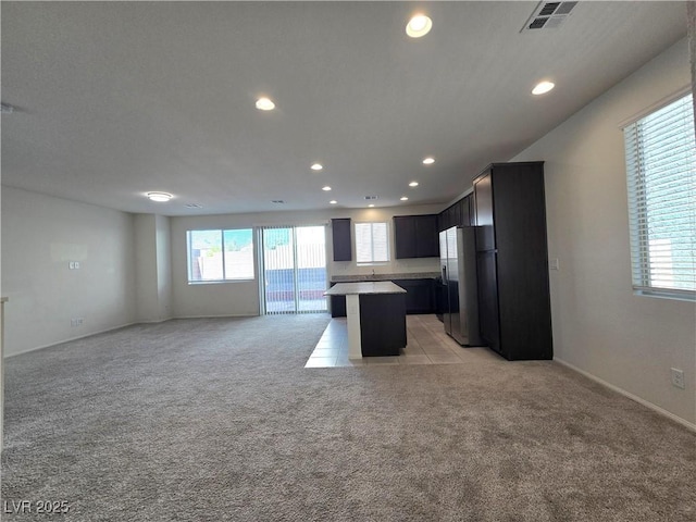 5817 Bonita Rose St, Las Vegas, NV 89113 - kitchen featuring stainless steel fridge, recessed lighting, open floor plan, a kitchen island, and light colored carpet