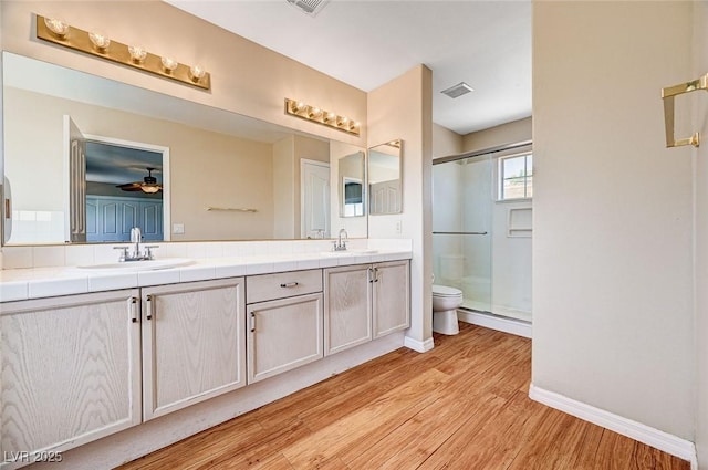 7813 Falconwing Ave, Las Vegas, NV 89131 - bathroom with wood finished floors, a shower stall, double vanity, and a ceiling fan