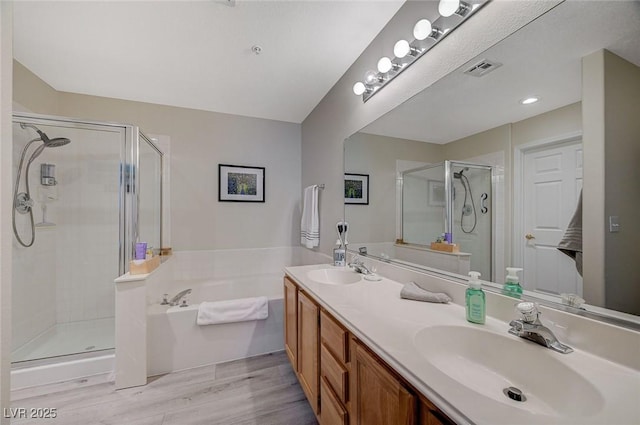 2925 Wigwam Pkwy Unit 123, Henderson, NV 89074 - bathroom featuring a stall shower, a bath, double vanity, and wood finished floors