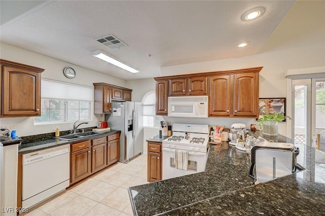 2925 Wigwam Pkwy Unit 123, Henderson, NV 89074 - kitchen with white appliances, healthy amount of natural light, recessed lighting, dark stone countertops, and light tile patterned floors