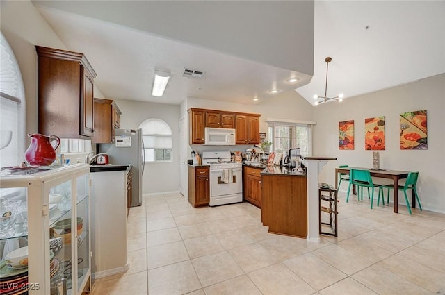 2925 Wigwam Pkwy Unit 123, Henderson, NV 89074 - kitchen with white appliances, a peninsula, a breakfast bar area, light tile patterned floors, and dark countertops
