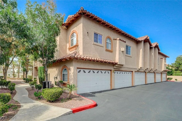 2925 Wigwam Pkwy Unit 123, Henderson, NV 89074 - mediterranean / spanish home with stucco siding, driveway, a tile roof, and a garage