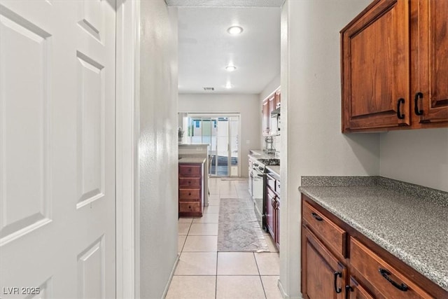 4916 White Jade St, North Las Vegas, NV 89081 - kitchen with light tile patterned flooring and gas range