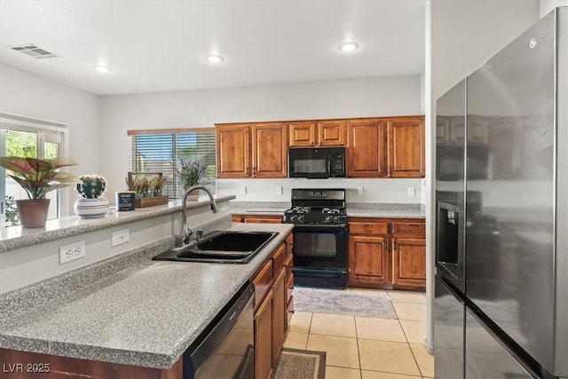 4916 White Jade St, North Las Vegas, NV 89081 - kitchen with black appliances, brown cabinets, light tile patterned floors, recessed lighting, and a center island with sink