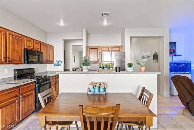 4916 White Jade St, North Las Vegas, NV 89081 - kitchen with black appliances, light tile patterned floors, light countertops, brown cabinetry, and recessed lighting