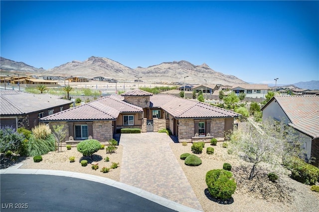 12168 Dorada Coast Ave, Las Vegas, NV 89138 - view of front facade with a tile roof, a mountain view, a residential view, driveway, and stone siding