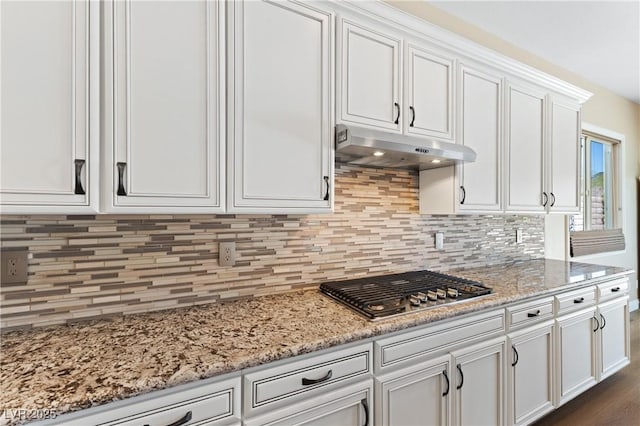12168 Dorada Coast Ave, Las Vegas, NV 89138 - kitchen with under cabinet range hood, stainless steel gas stovetop, white cabinets, and decorative backsplash