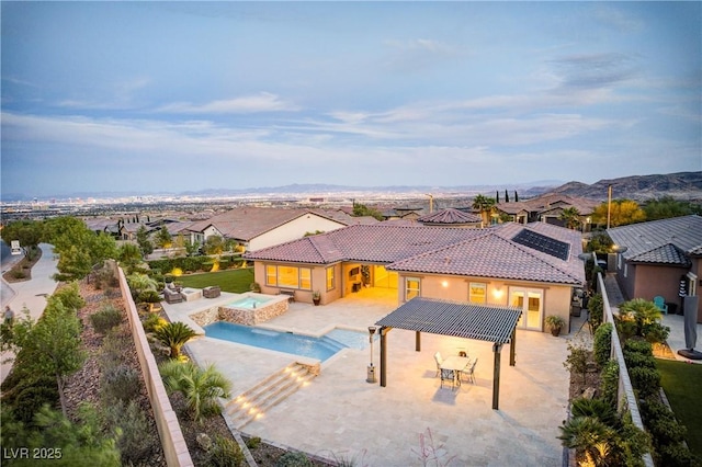12168 Dorada Coast Ave, Las Vegas, NV 89138 - view of swimming pool featuring a pool with connected hot tub, outdoor dining area, a patio area, a residential view, and a fenced backyard