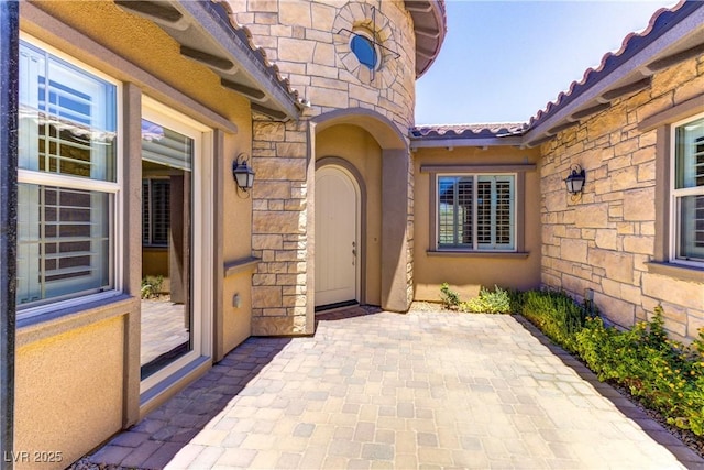 12168 Dorada Coast Ave, Las Vegas, NV 89138 - property entrance with stone siding, a patio, a tile roof, and stucco siding