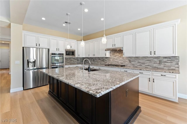 12168 Dorada Coast Ave, Las Vegas, NV 89138 - kitchen with appliances with stainless steel finishes, white cabinetry, light wood finished floors, and recessed lighting