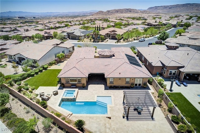 12168 Dorada Coast Ave, Las Vegas, NV 89138 - view of swimming pool featuring a residential view, a pool with connected hot tub, a fenced backyard, and a mountain view