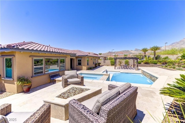 12168 Dorada Coast Ave, Las Vegas, NV 89138 - view of pool with a patio, a pool with connected hot tub, an outdoor living space with a fire pit, and a mountain view
