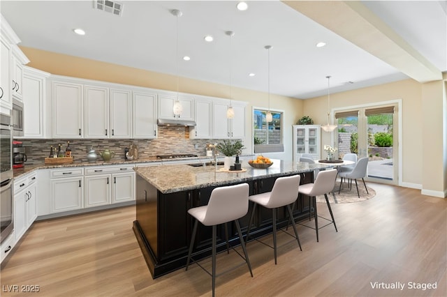 12168 Dorada Coast Ave, Las Vegas, NV 89138 - kitchen featuring backsplash, white cabinetry, light wood-type flooring, recessed lighting, and a center island with sink