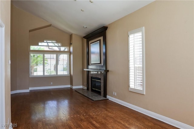 2208 Fiero Dr, Las Vegas, NV 89134 - unfurnished living room with dark wood-type flooring, a tiled fireplace, and vaulted ceiling