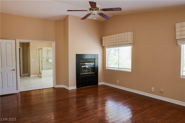 2208 Fiero Dr, Las Vegas, NV 89134 - unfurnished living room featuring ceiling fan, wood-type flooring, a tiled fireplace, and lofted ceiling