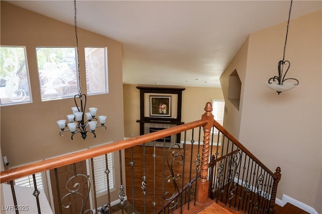 2208 Fiero Dr, Las Vegas, NV 89134 - stairway featuring a chandelier, wood finished floors, and a fireplace