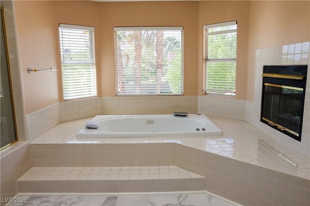 2208 Fiero Dr, Las Vegas, NV 89134 - bathroom featuring a tiled fireplace, a bath, and plenty of natural light
