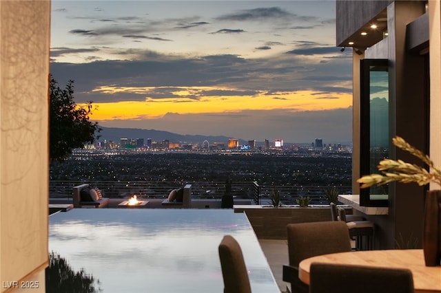 1491 Reims Dr, Henderson, NV 89012 - patio terrace at dusk with a city view, an outdoor fire pit, and a balcony