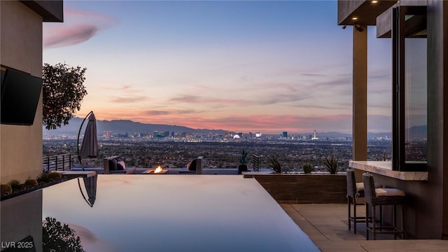 1491 Reims Dr, Henderson, NV 89012 - patio terrace at dusk with an outdoor fire pit, a city view, and a patio