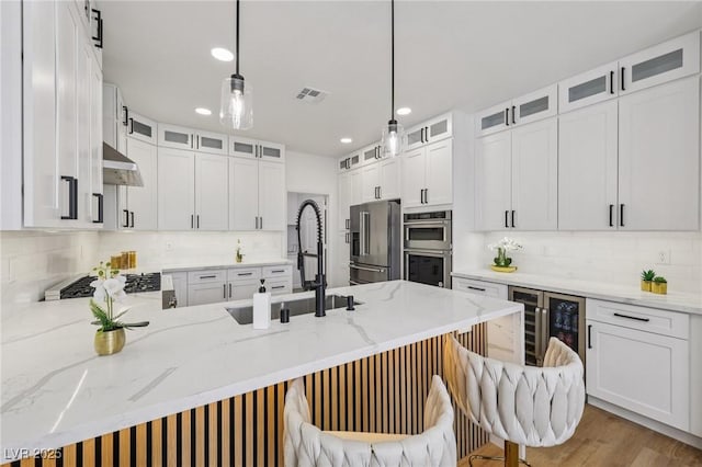 9900 Summer Ash Ct Unit 103, Las Vegas, NV 89134 - kitchen with stainless steel appliances, a peninsula, wine cooler, tasteful backsplash, and recessed lighting