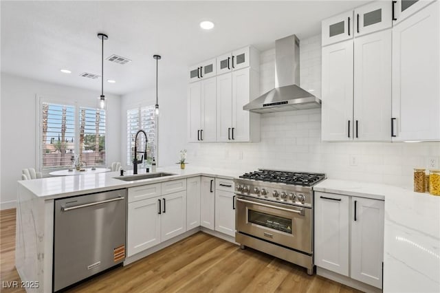 9900 Summer Ash Ct Unit 103, Las Vegas, NV 89134 - kitchen featuring wall chimney range hood, stainless steel appliances, a peninsula, light wood-type flooring, and recessed lighting