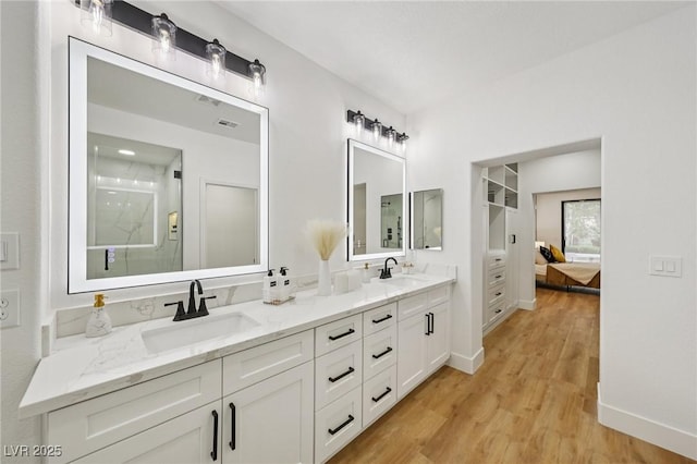 9900 Summer Ash Ct Unit 103, Las Vegas, NV 89134 - ensuite bathroom with double vanity, wood finished floors, and a shower with shower door