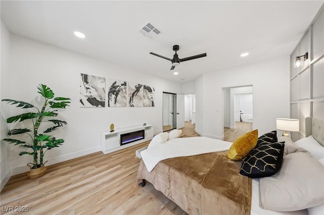 9900 Summer Ash Ct Unit 103, Las Vegas, NV 89134 - bedroom with light wood-type flooring, a glass covered fireplace, recessed lighting, and ceiling fan