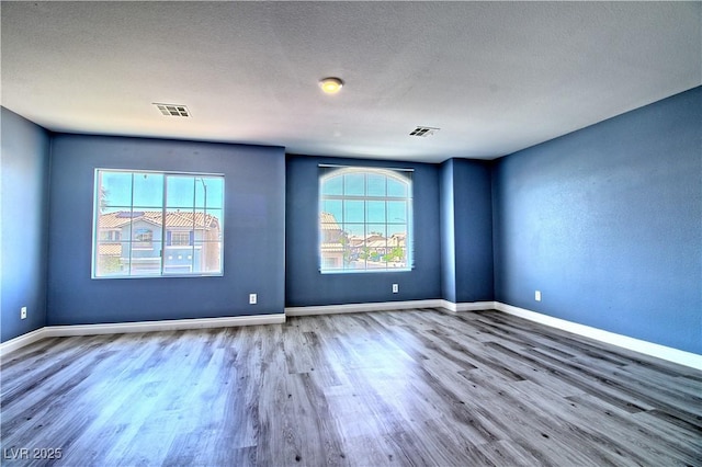 6042 Thorne Bay Ct, Las Vegas, NV 89110 - empty room with wood finished floors, plenty of natural light, and a textured ceiling