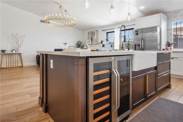 4774 Walteta Way, Las Vegas, NV 89119 - kitchen featuring wine cooler, a chandelier, light wood finished floors, and healthy amount of natural light