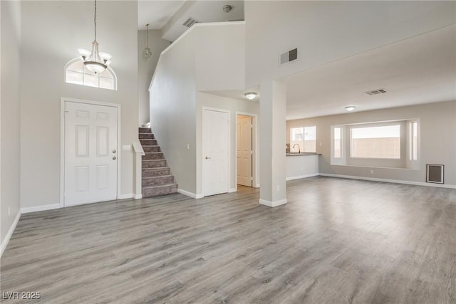 7816 Calico Flower Ave, Las Vegas, NV 89128 - foyer entrance featuring wood finished floors, stairs, high vaulted ceiling, and a chandelier