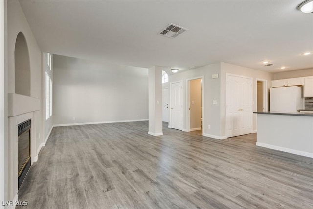 7816 Calico Flower Ave, Las Vegas, NV 89128 - unfurnished living room with light wood finished floors, a tile fireplace, and recessed lighting