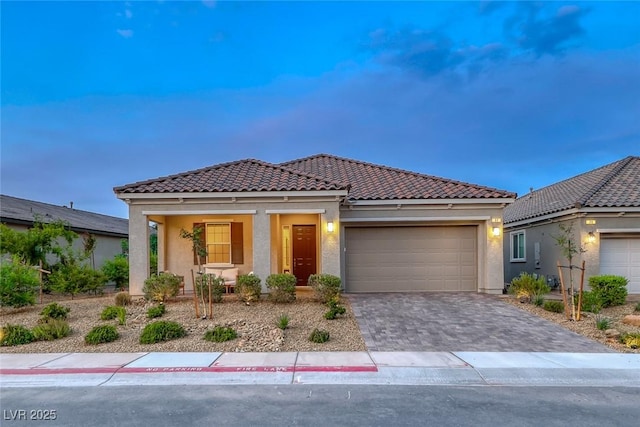 32 Tatahatso Point St, Henderson, NV 89011 - mediterranean / spanish-style house with stucco siding, an attached garage, a tiled roof, and covered porch