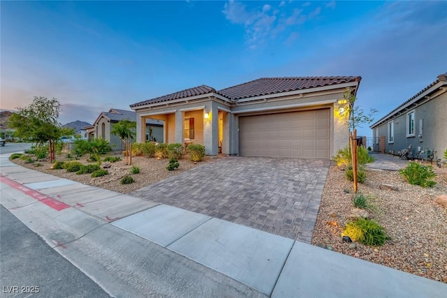 32 Tatahatso Point St, Henderson, NV 89011 - mediterranean / spanish-style home featuring a tile roof, stucco siding, a garage, and decorative driveway