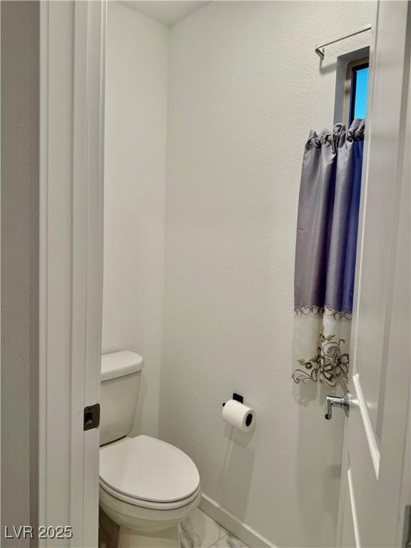 10411 Rose Palisade St, Las Vegas, NV 89141 - bathroom with marble look tile flooring and toilet