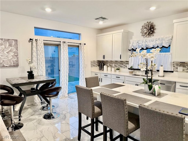 10411 Rose Palisade St, Las Vegas, NV 89141 - kitchen featuring a kitchen bar, backsplash, light marble finish floors, white cabinetry, and recessed lighting