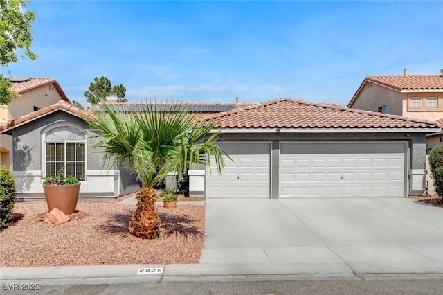 8926 Termoli St, Las Vegas, NV 89123 - mediterranean / spanish-style house with a garage, concrete driveway, roof mounted solar panels, stucco siding, and a tile roof