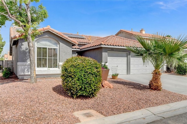 8926 Termoli St, Las Vegas, NV 89123 - view of front of home featuring stucco siding, an attached garage, solar panels, concrete driveway, and a tile roof