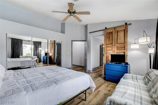 8926 Termoli St, Las Vegas, NV 89123 - bedroom featuring vaulted ceiling, light wood-style flooring, a barn door, ceiling fan, and a closet