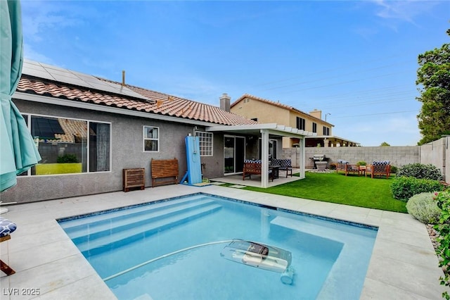 8926 Termoli St, Las Vegas, NV 89123 - rear view of property featuring a tile roof, roof mounted solar panels, a fenced backyard, a patio area, and stucco siding