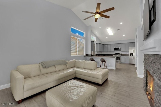 5509 Rose Thicket St, Las Vegas, NV 89130 - living area featuring a stone fireplace, high vaulted ceiling, ceiling fan, light wood finished floors, and recessed lighting