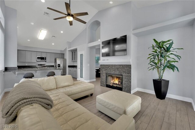5509 Rose Thicket St, Las Vegas, NV 89130 - living area featuring ceiling fan, light wood finished floors, high vaulted ceiling, a fireplace, and recessed lighting