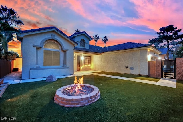 5509 Rose Thicket St, Las Vegas, NV 89130 - back of property at dusk featuring a fire pit and stucco siding