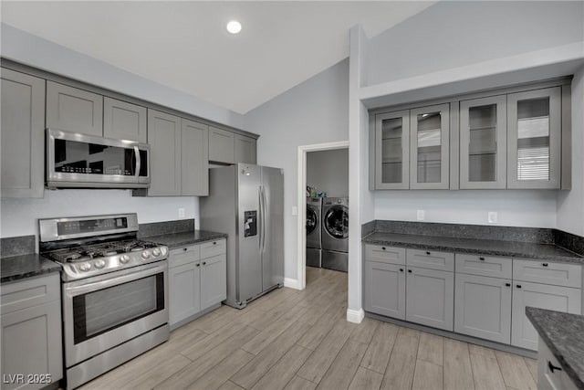 5509 Rose Thicket St, Las Vegas, NV 89130 - kitchen with stainless steel appliances, washer and dryer, lofted ceiling, gray cabinets, and light wood-style flooring