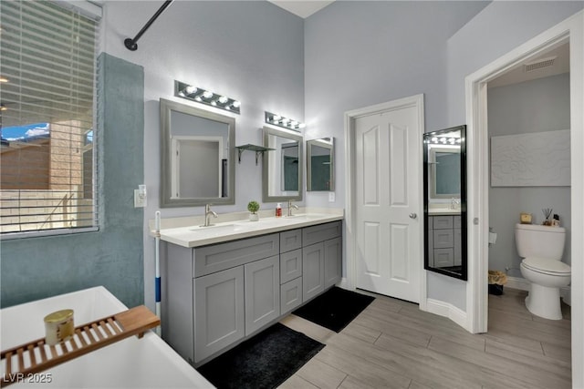 5509 Rose Thicket St, Las Vegas, NV 89130 - bathroom featuring a freestanding tub, double vanity, and wood finished floors