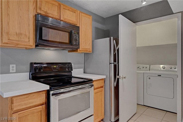 201 Mission Laguna Ln Unit 104, Las Vegas, NV 89107 - kitchen with range with electric stovetop, black microwave, independent washer and dryer, light tile patterned floors, and light countertops