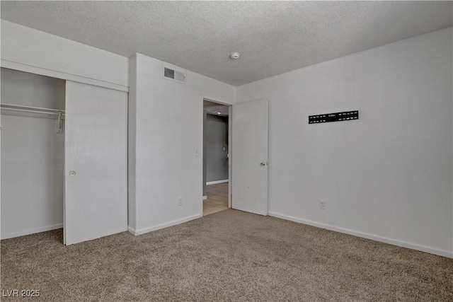 201 Mission Laguna Ln Unit 104, Las Vegas, NV 89107 - unfurnished bedroom with carpet flooring, a textured ceiling, and a closet