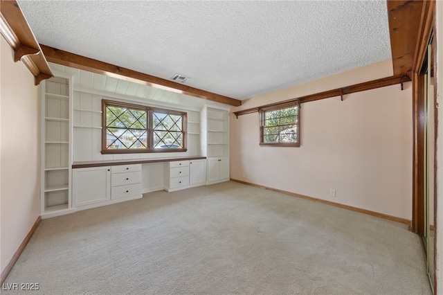 2400 Llewellyn Dr, Las Vegas, NV 89102 - unfurnished bedroom with built in study area, a textured ceiling, light carpet, and beam ceiling
