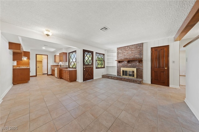 2400 Llewellyn Dr, Las Vegas, NV 89102 - unfurnished living room with a textured ceiling, light tile patterned floors, and a fireplace