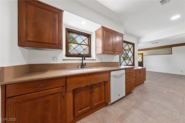 2400 Llewellyn Dr, Las Vegas, NV 89102 - kitchen with white dishwasher, brown cabinets, light countertops, and light tile patterned flooring